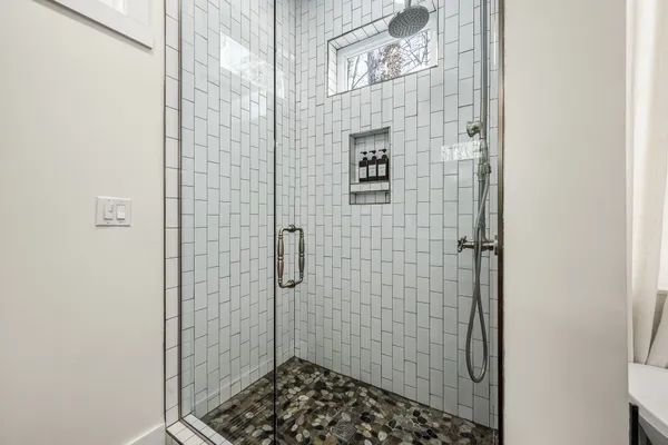a bathroom with a sink mirror and shower