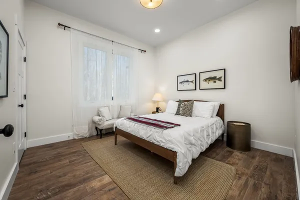 an empty room with wooden floor closet and windows