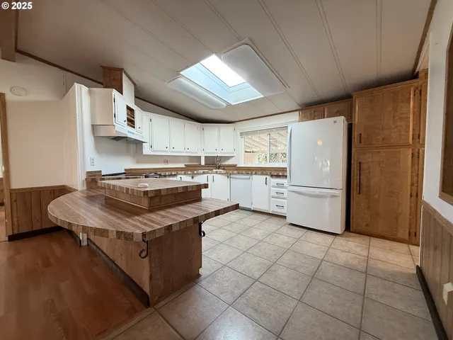 a white kitchen with granite countertop stainless steel appliances