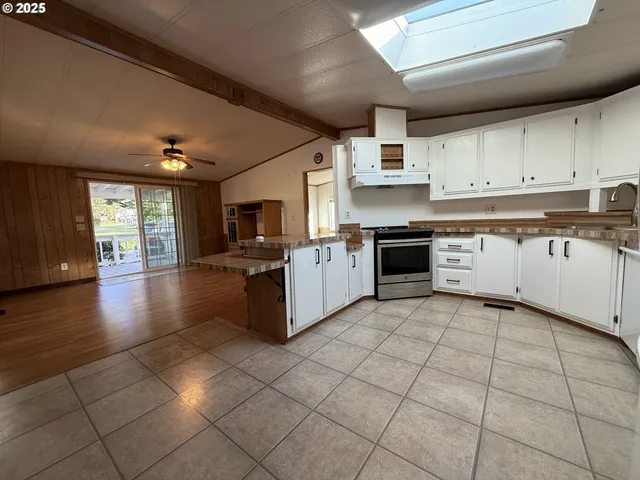 a kitchen with stainless steel appliances granite countertop a refrigerator a stove and a sink