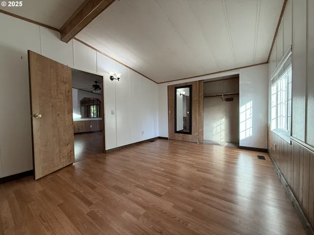 a view of a livingroom with wooden floor and a window