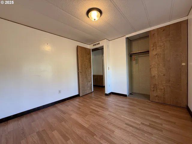 an empty room with wooden floor and a window