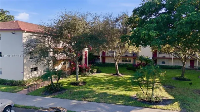 a view of a table and chairs in a yard with palm trees