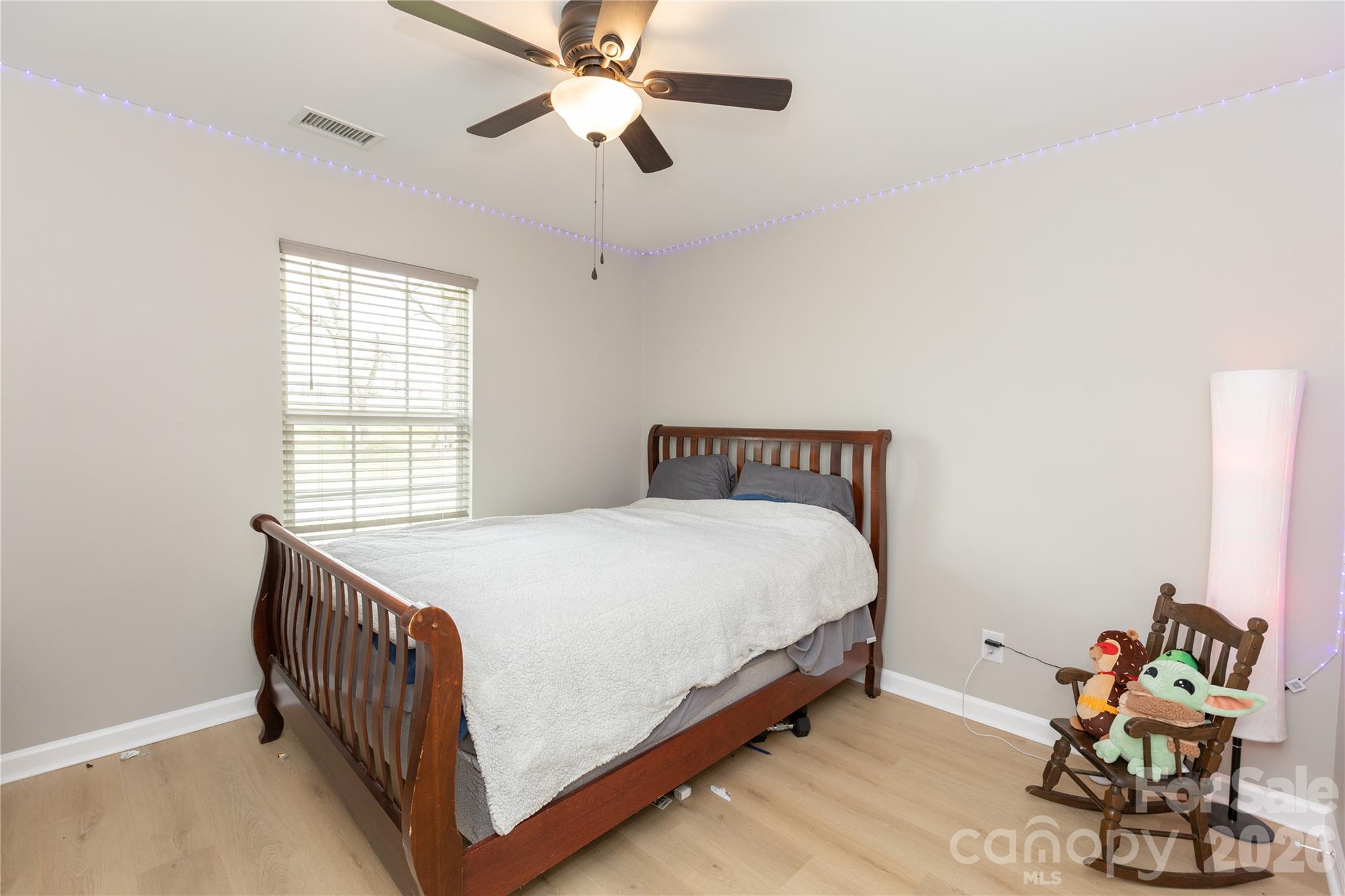 5126 Monroe-Ansonville Road Wingate, NC 28174 - Photo 22 of 28 a bedroom with a bed and a chandelier