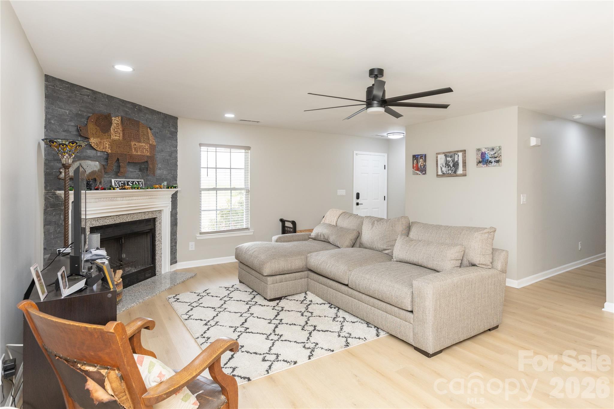 5126 Monroe-Ansonville Road Wingate, NC 28174 - Photo 5 of 28 a living room with furniture a fireplace and a chandelier