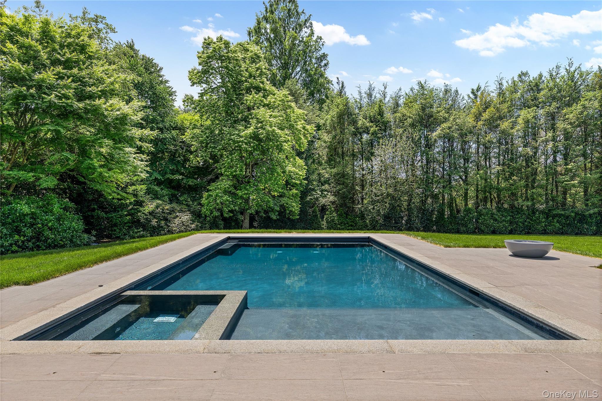42 Mamaroneck Road Scarsdale, NY 10583 - Photo 7 of 47 The stunning Gunite pool with integrated spa, sun shelf, and automatic cover creates your own private backyard retreat.