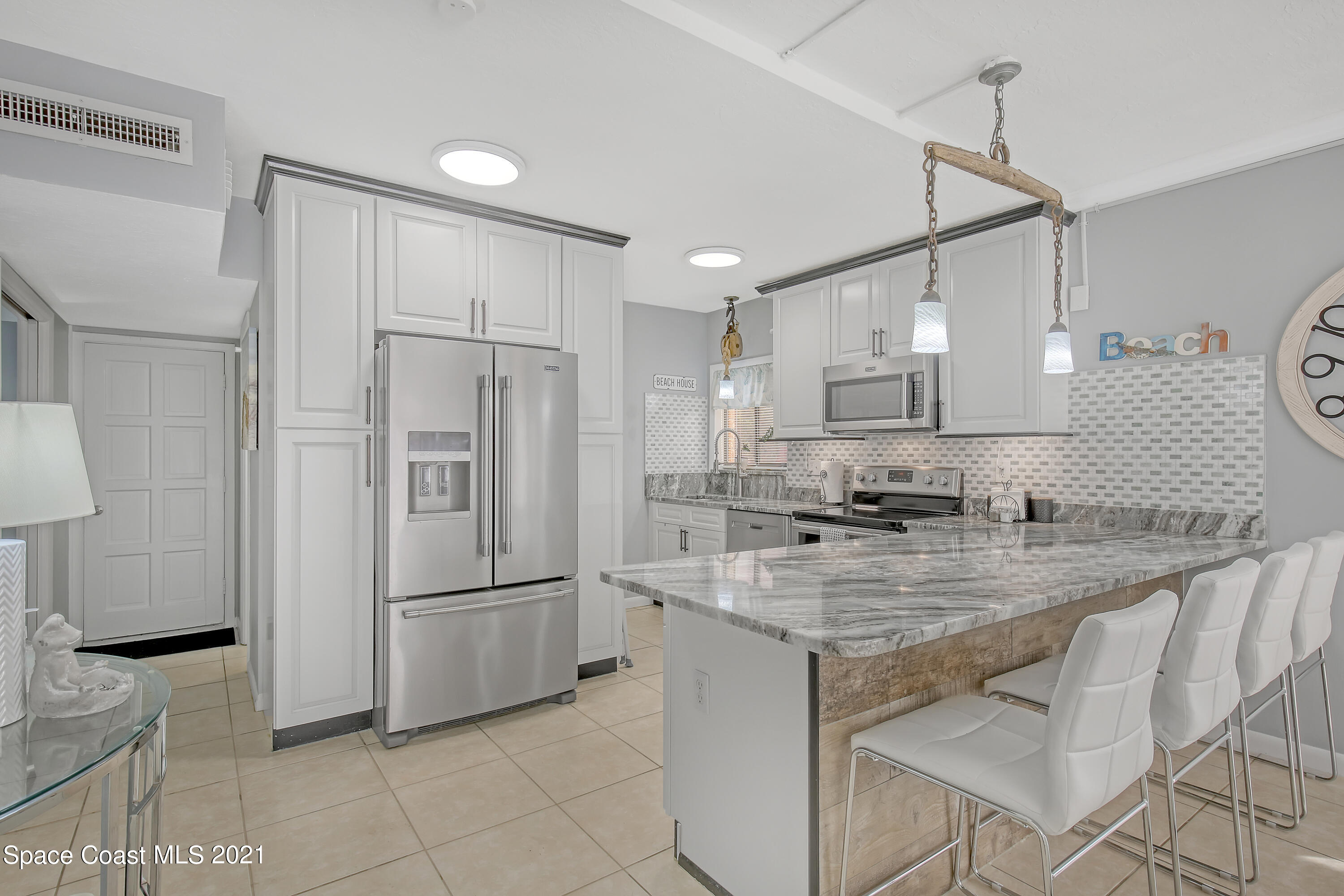 5000 Ocean Beach Boulevard, Unit C5 Cocoa Beach, FL 32931 - Photo 12 of 43 a kitchen with kitchen island a counter top space appliances and cabinets