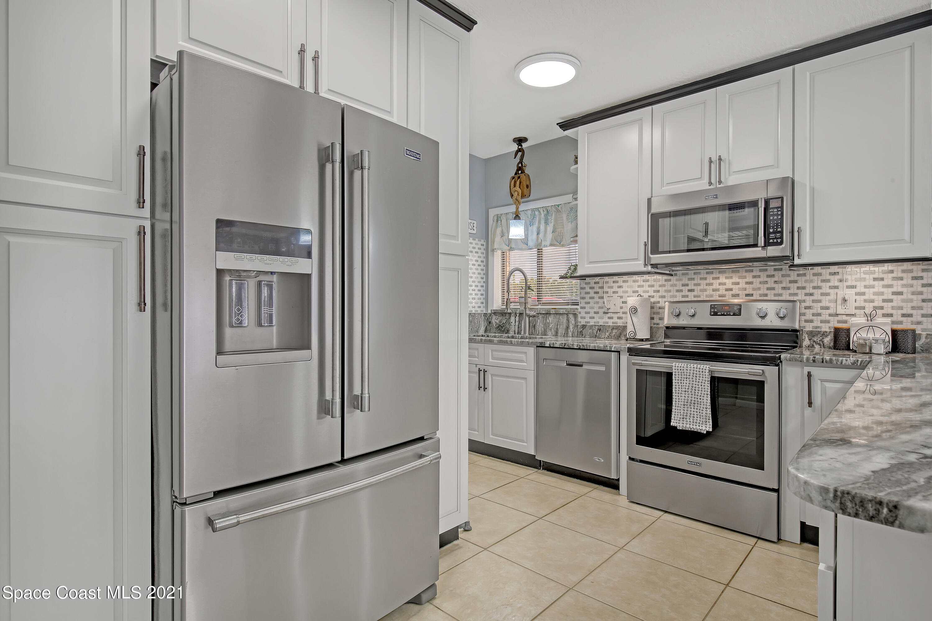 5000 Ocean Beach Boulevard, Unit C5 Cocoa Beach, FL 32931 - Photo 13 of 43 a kitchen with stainless steel appliances granite countertop a refrigerator and a stove top oven