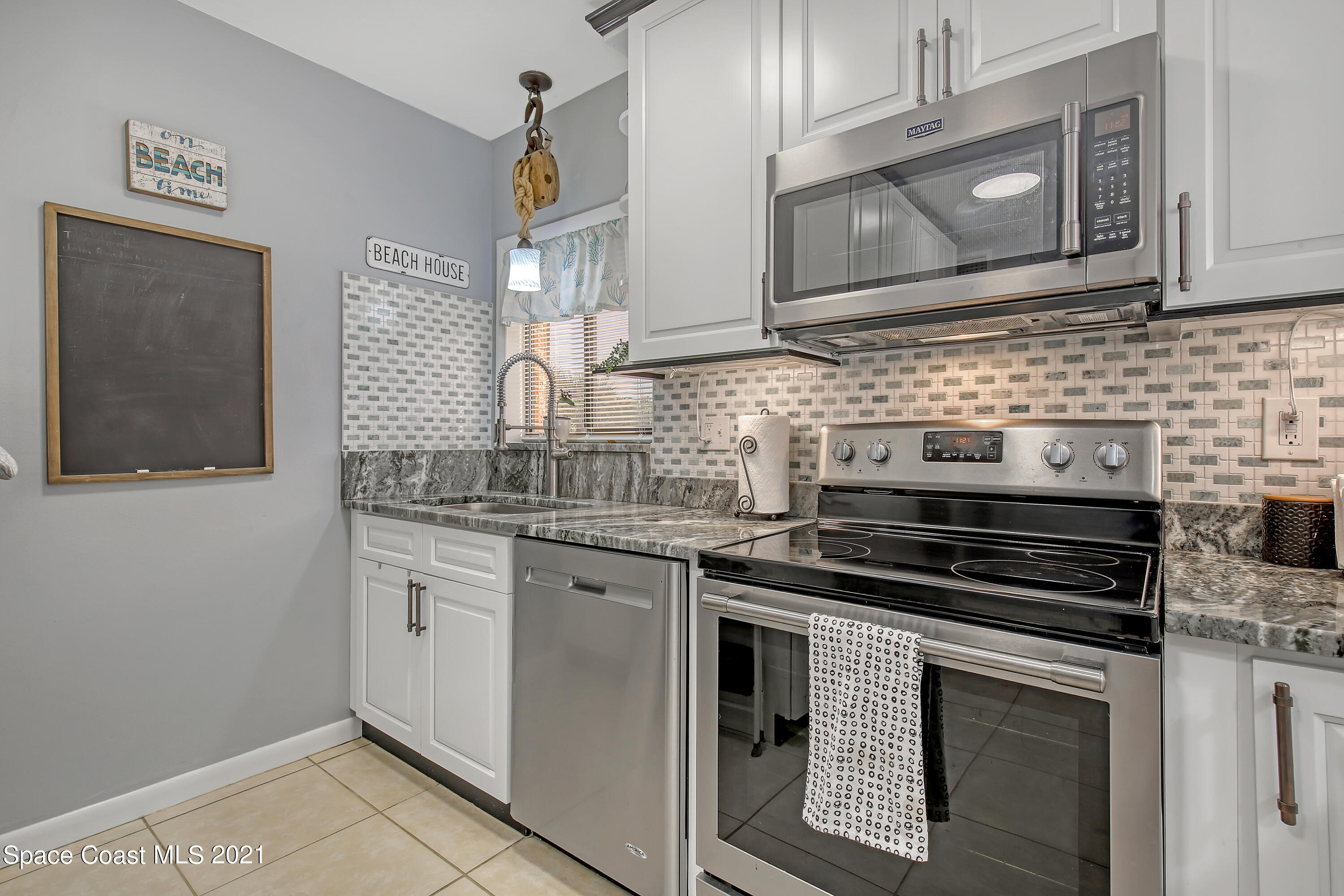 5000 Ocean Beach Boulevard, Unit C5 Cocoa Beach, FL 32931 - Photo 14 of 43 a kitchen with stainless steel appliances granite countertop a stove and a microwave