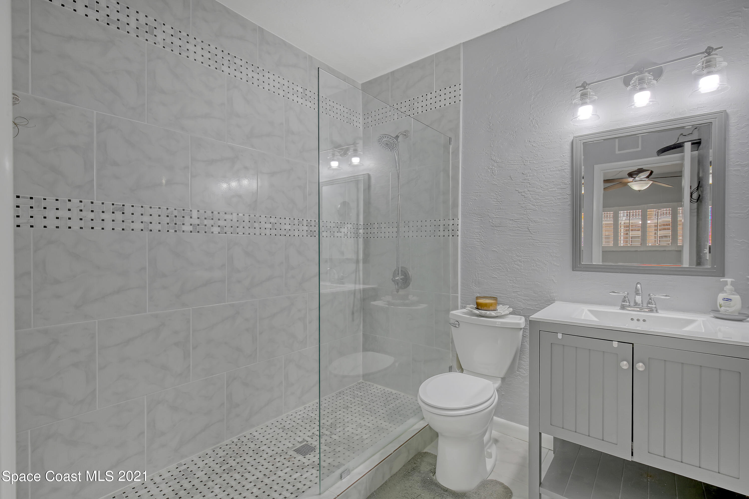 5000 Ocean Beach Boulevard, Unit C5 Cocoa Beach, FL 32931 - Photo 19 of 43 a bathroom with a toilet sink vanity granite and shower