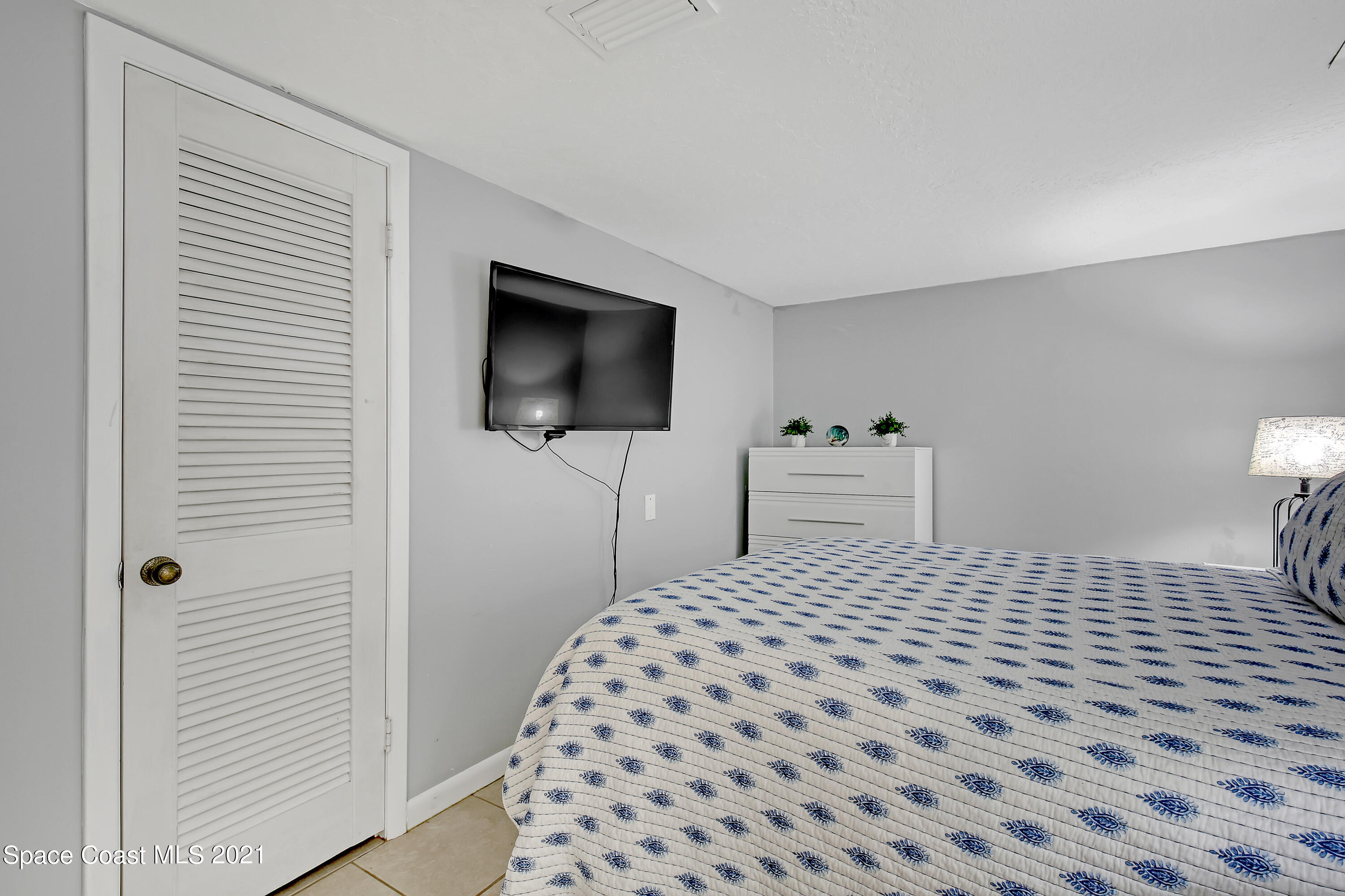 5000 Ocean Beach Boulevard, Unit C5 Cocoa Beach, FL 32931 - Photo 20 of 43 a bedroom with a bed and a flat screen tv