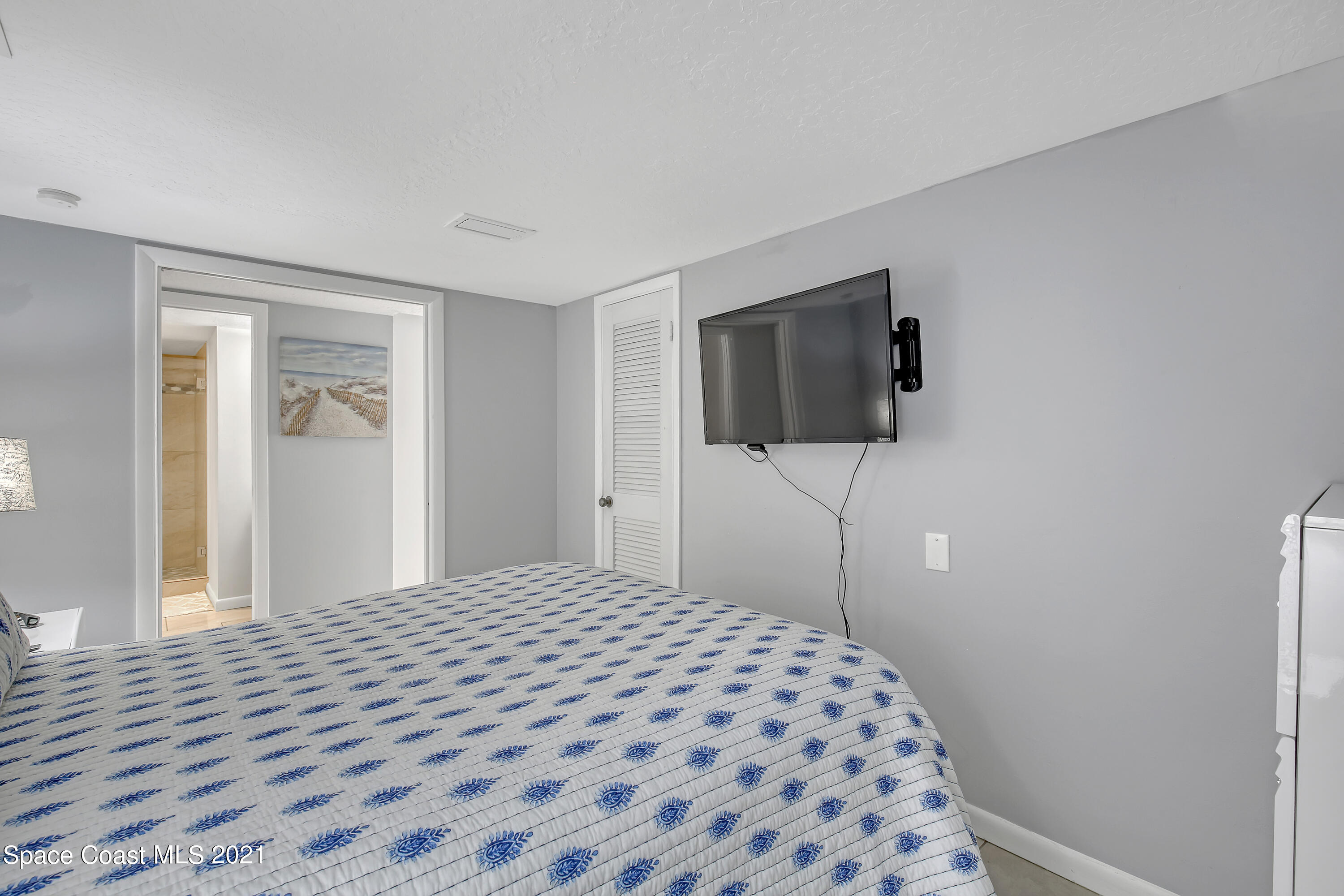5000 Ocean Beach Boulevard, Unit C5 Cocoa Beach, FL 32931 - Photo 21 of 43 a bedroom with a bed and a flat screen tv