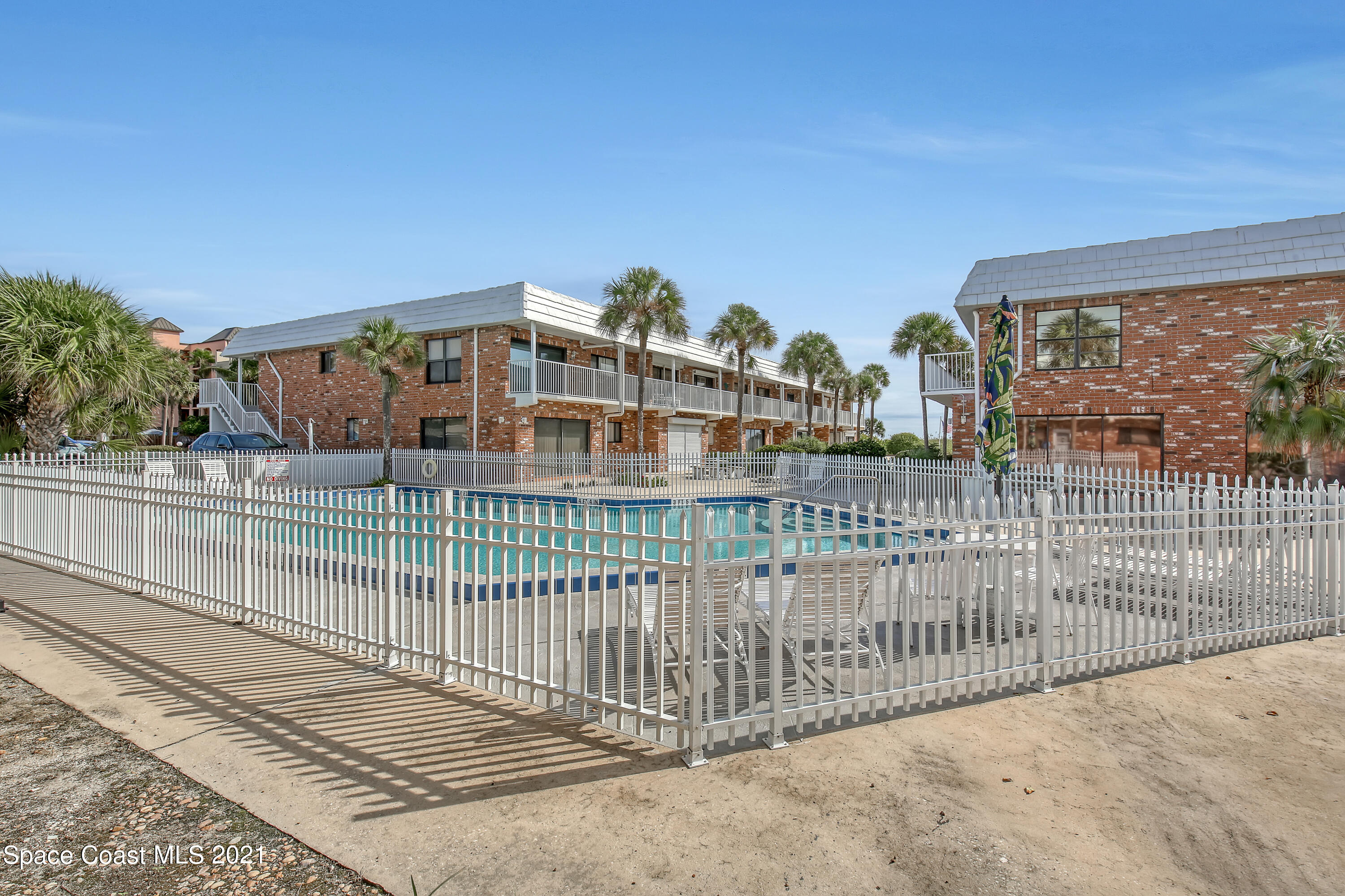 5000 Ocean Beach Boulevard, Unit C5 Cocoa Beach, FL 32931 - Photo 30 of 43 a view of a balcony with a floor to ceiling window and wooden fence