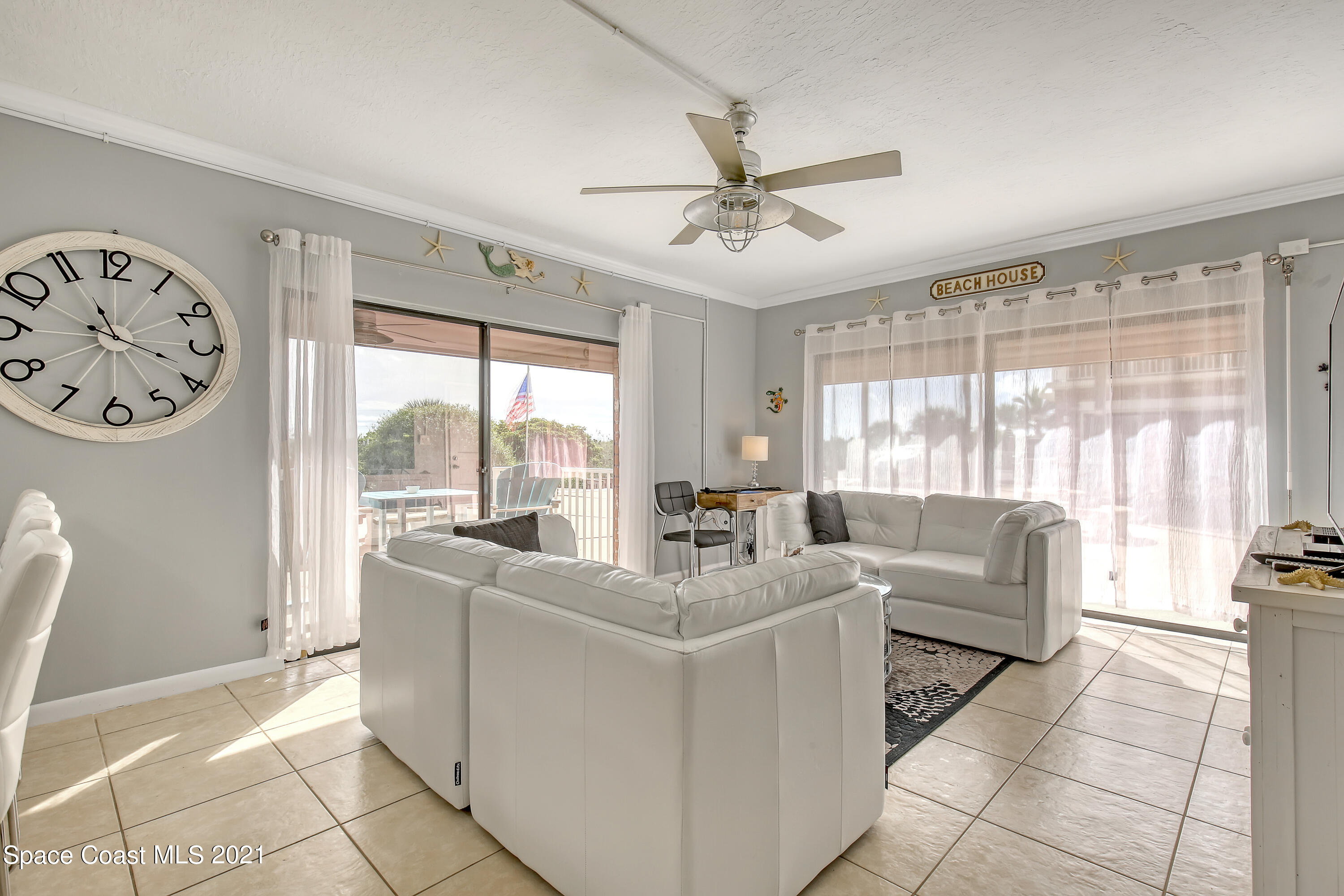 5000 Ocean Beach Boulevard, Unit C5 Cocoa Beach, FL 32931 - Photo 8 of 43 a living room with furniture and a large window