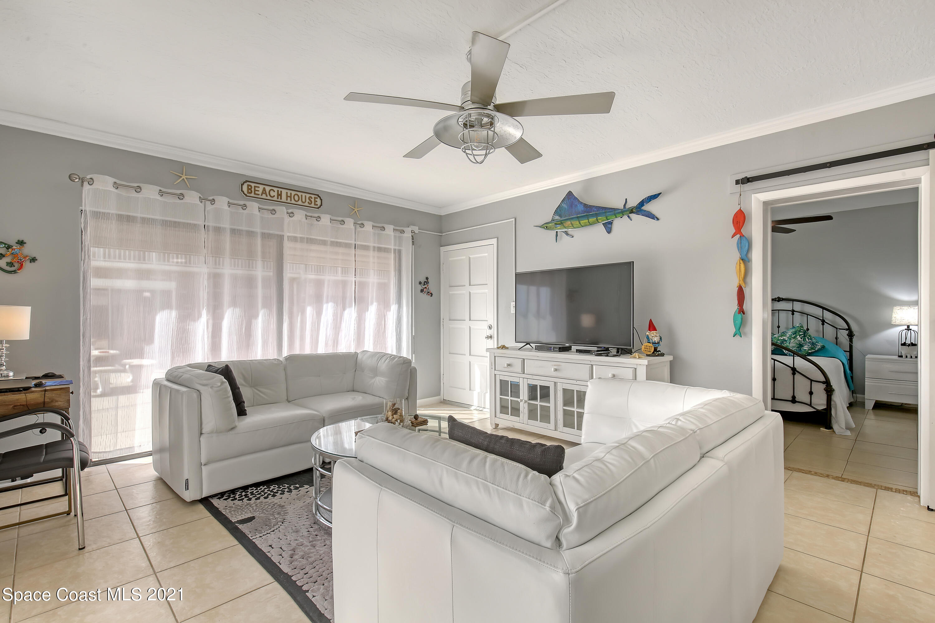 5000 Ocean Beach Boulevard, Unit C5 Cocoa Beach, FL 32931 - Photo 10 of 43 a living room with furniture and a flat screen tv