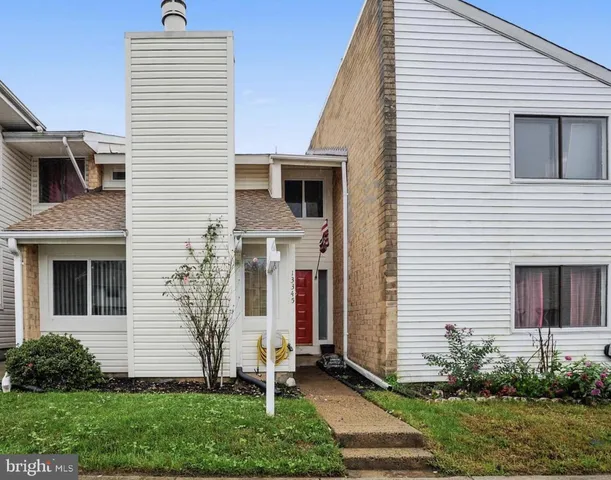 a view of a house with brick walls and a yard with plants
