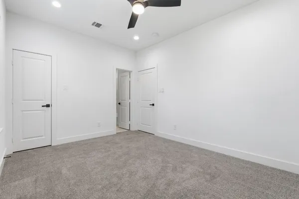 an empty room with a ceiling fan and window