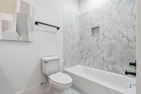 a white toilet sitting next to a bath tub