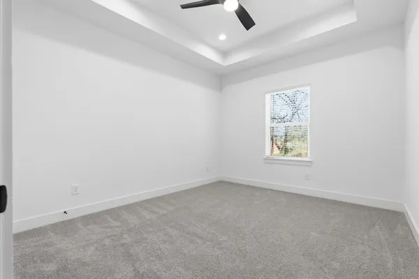 an empty room with a window and a ceiling fan