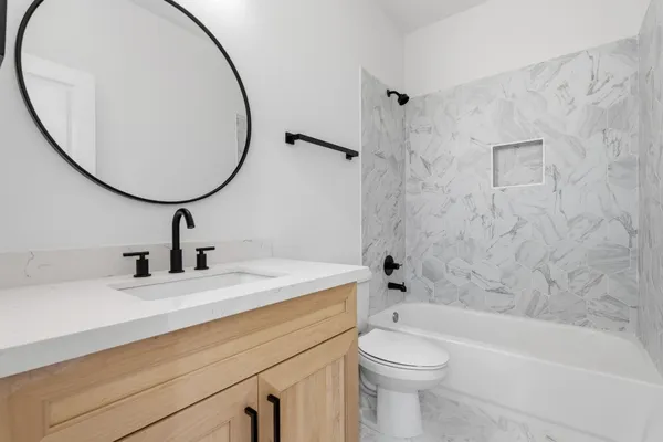 a bathroom with a sink a toilet and a mirror