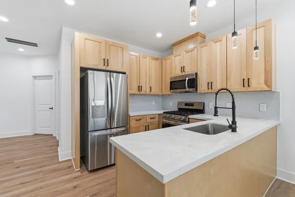 a kitchen with granite countertop a refrigerator and a sink
