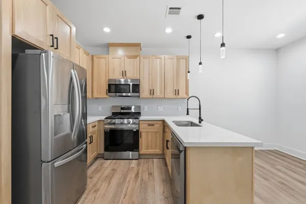a kitchen with stainless steel appliances a refrigerator sink and microwave