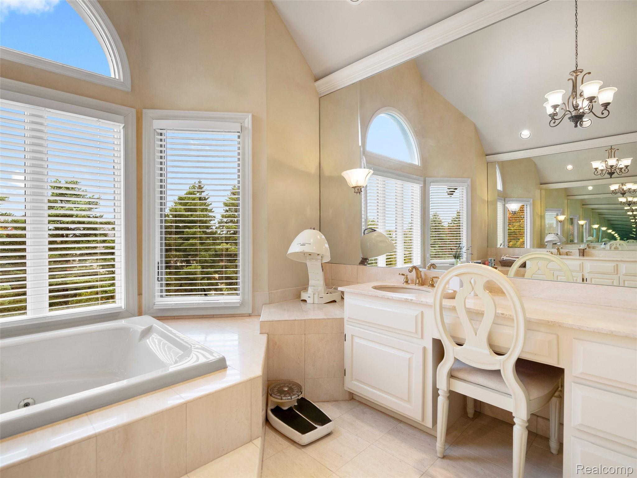 5724 Murfield Drive Rochester, MI 48306 - Photo 84 of 99 Full bathroom featuring a garden tub, a chandelier, vanity, high vaulted ceiling, and light tile patterned flooring