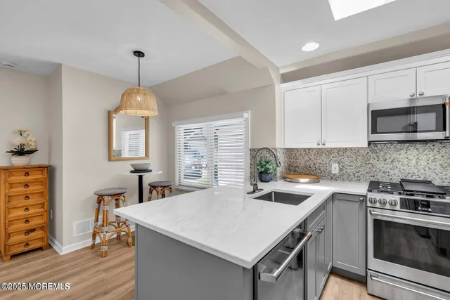 a kitchen with a stove a sink a window and dining table