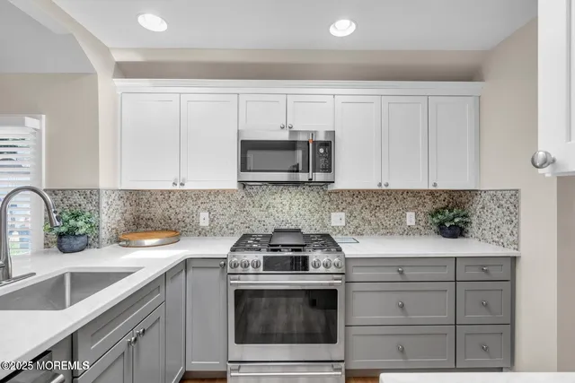 a kitchen with granite countertop white cabinets and a stove