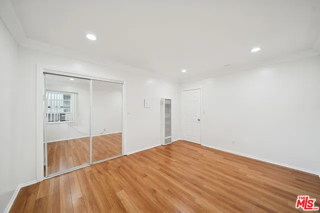 a view of empty room with wooden floor