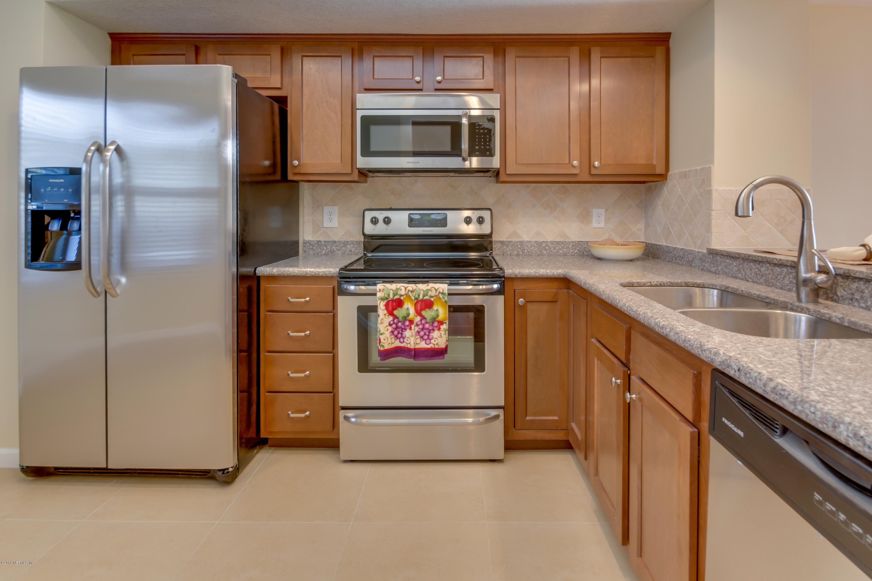 11788 Wattle Tree Road West Jacksonville, FL 32246 - Photo 8 of 23 a kitchen with stainless steel appliances granite countertop a stove a sink and a refrigerator