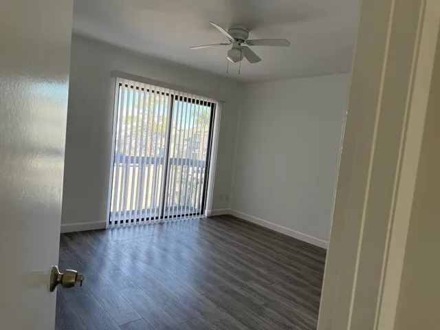an empty room with a window and a ceiling fan