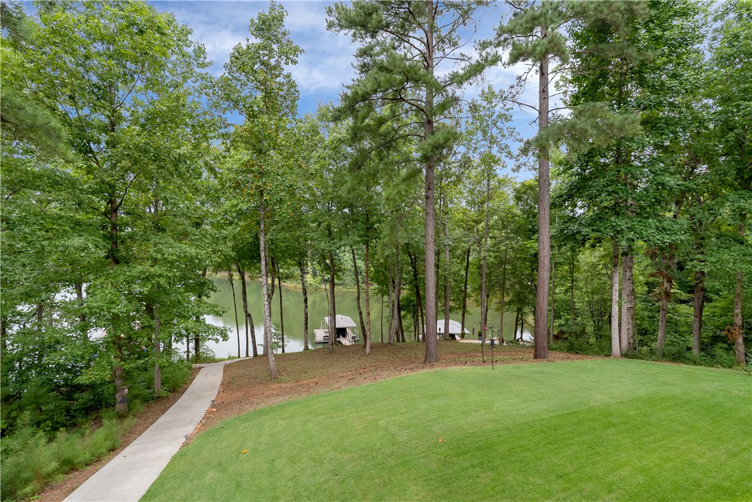 329 High Hampton Road Salem, SC 29676 - Photo 5 of 47 Mature trees line the gentle slope down to a serene waterfront setting with boat docks.