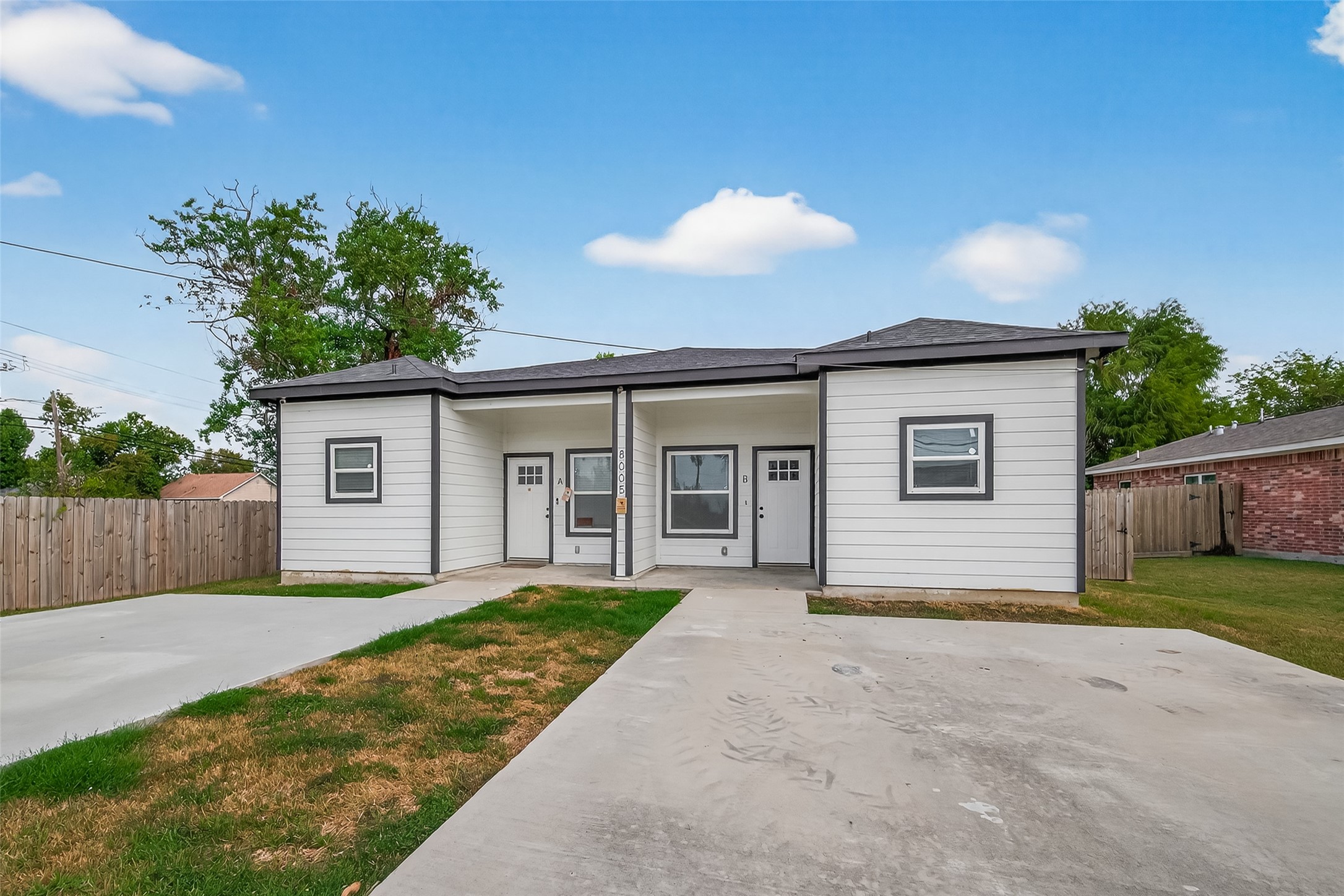 a view of a house with a yard and potted plants