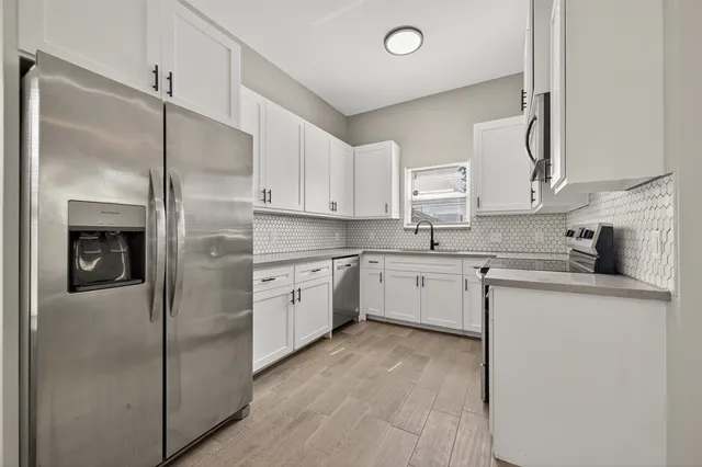 a kitchen with a refrigerator sink and cabinets