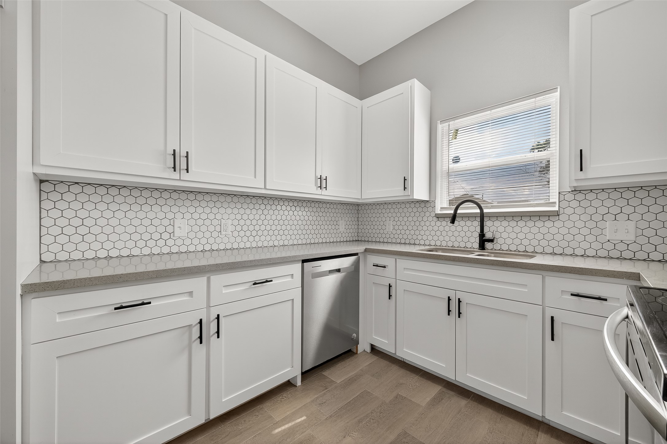8005 Sexton Street, Unit B Houston, TX 77028 - Photo 16 of 43 a kitchen with white cabinets and white appliances