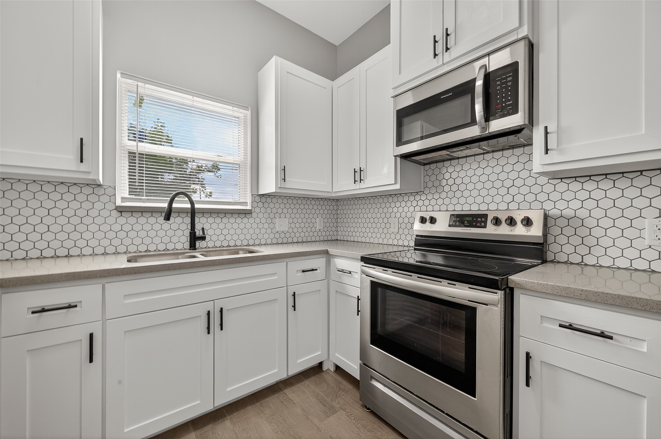 8005 Sexton Street, Unit B Houston, TX 77028 - Photo 17 of 43 a kitchen with cabinets stainless steel appliances a sink and a microwave