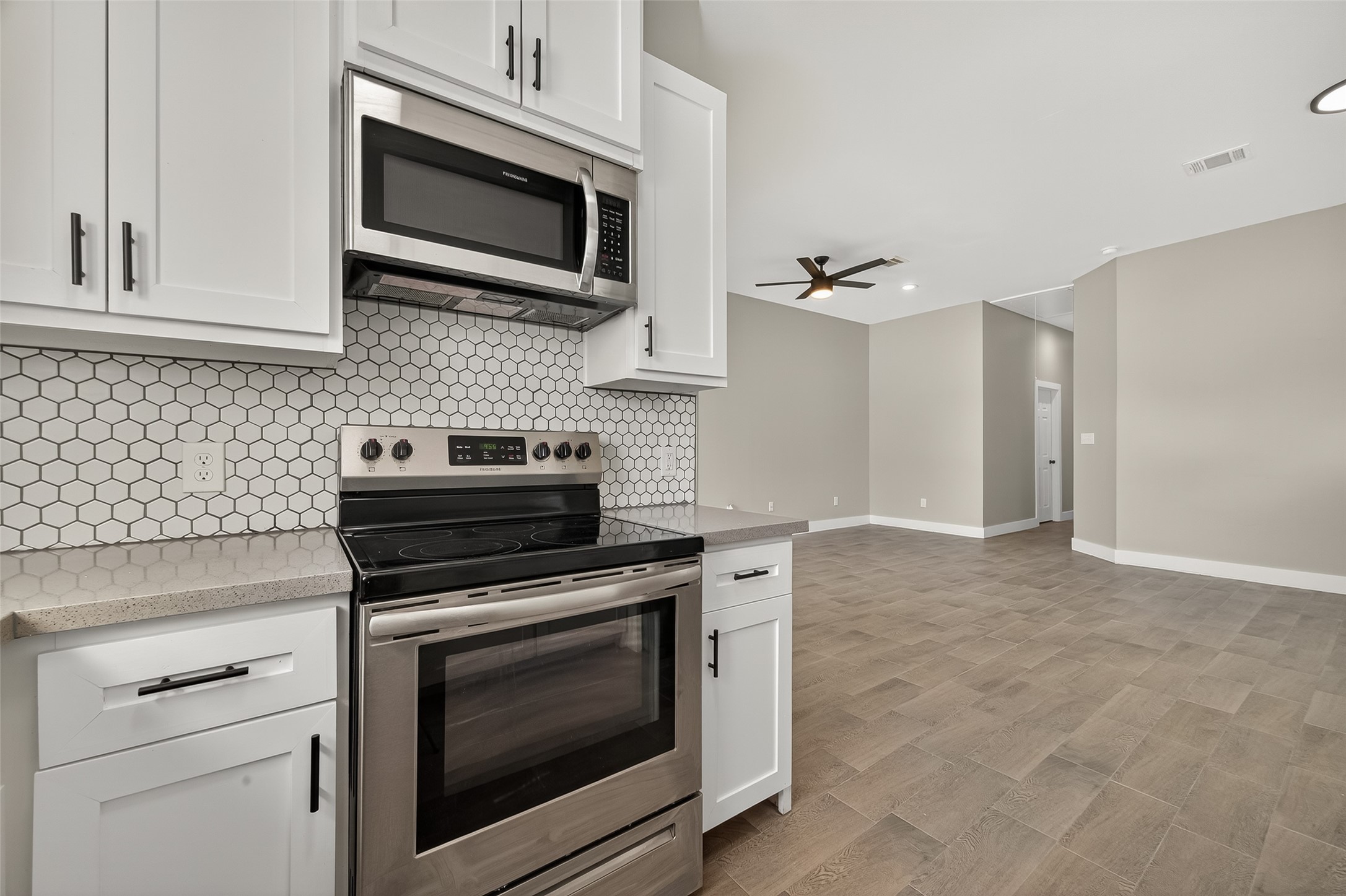 8005 Sexton Street, Unit B Houston, TX 77028 - Photo 18 of 43 a kitchen with stainless steel appliances granite countertop white cabinets a stove top oven