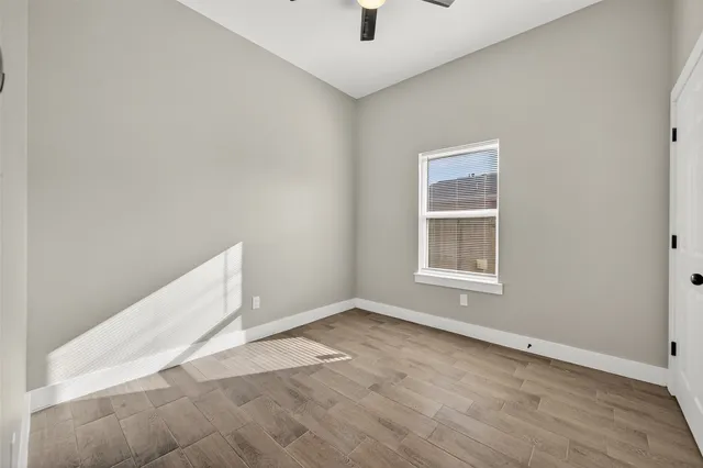 a view of an empty room with wooden floor