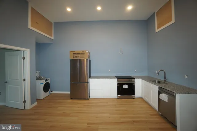 a view of a kitchen with a sink and refrigerator