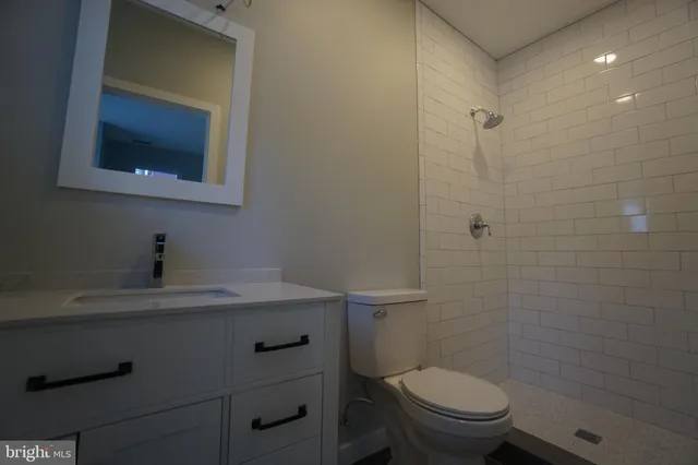 a white toilet sitting next to a bathroom sink and vanity