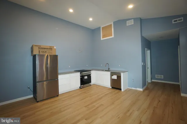 a kitchen with a refrigerator and a stove top oven