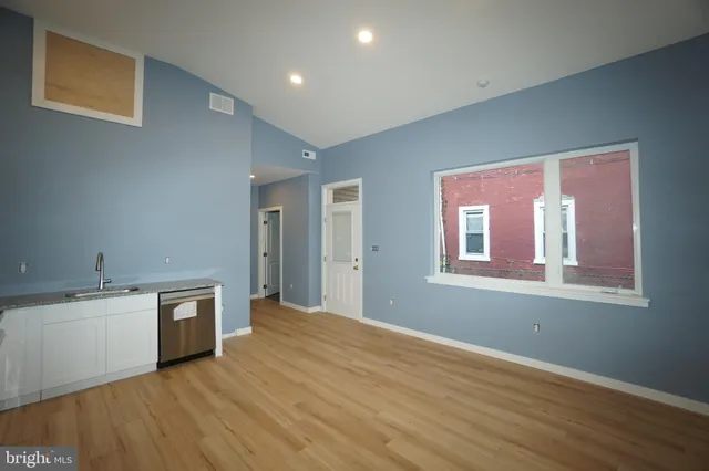 a view of a kitchen with wooden floor and a sink