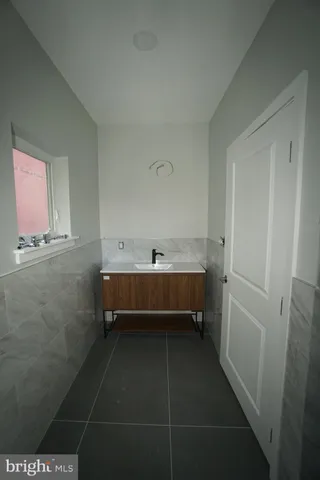 a bathroom with a double vanity sink a toilet and shower