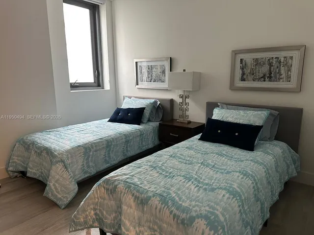 a bedroom with two beds and paintings on the wall