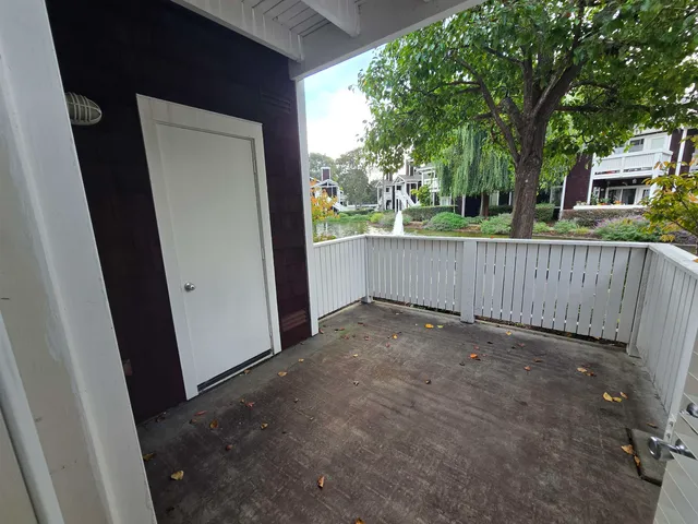 a view of a house with a fence and a tree