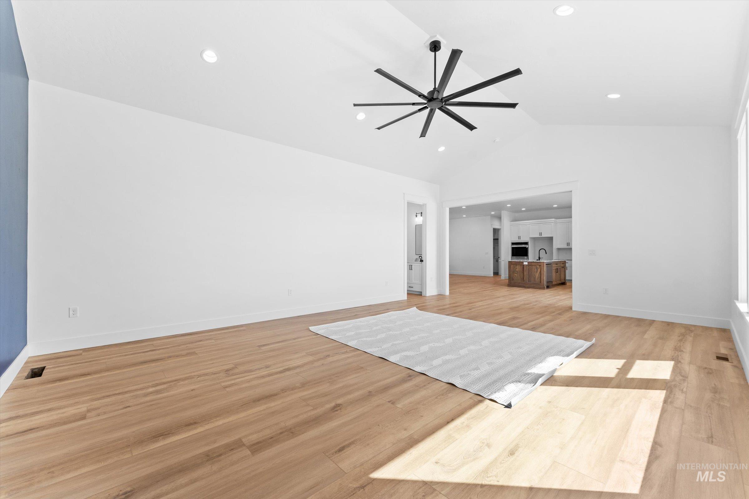 26219 Reed Lane Wilder, ID 83676 - Photo 11 of 35 Unfurnished living room featuring light wood finished floors, a ceiling fan, vaulted ceiling, and recessed lighting