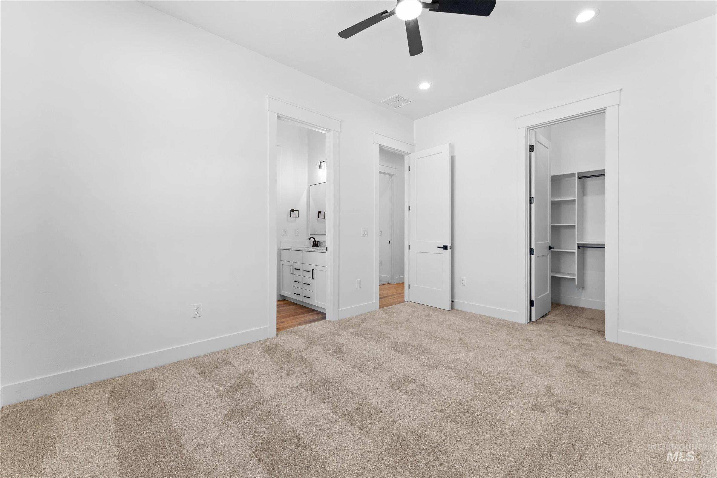 26219 Reed Lane Wilder, ID 83676 - Photo 14 of 35 Unfurnished bedroom with a spacious closet, light carpet, a ceiling fan, ensuite bathroom, and recessed lighting