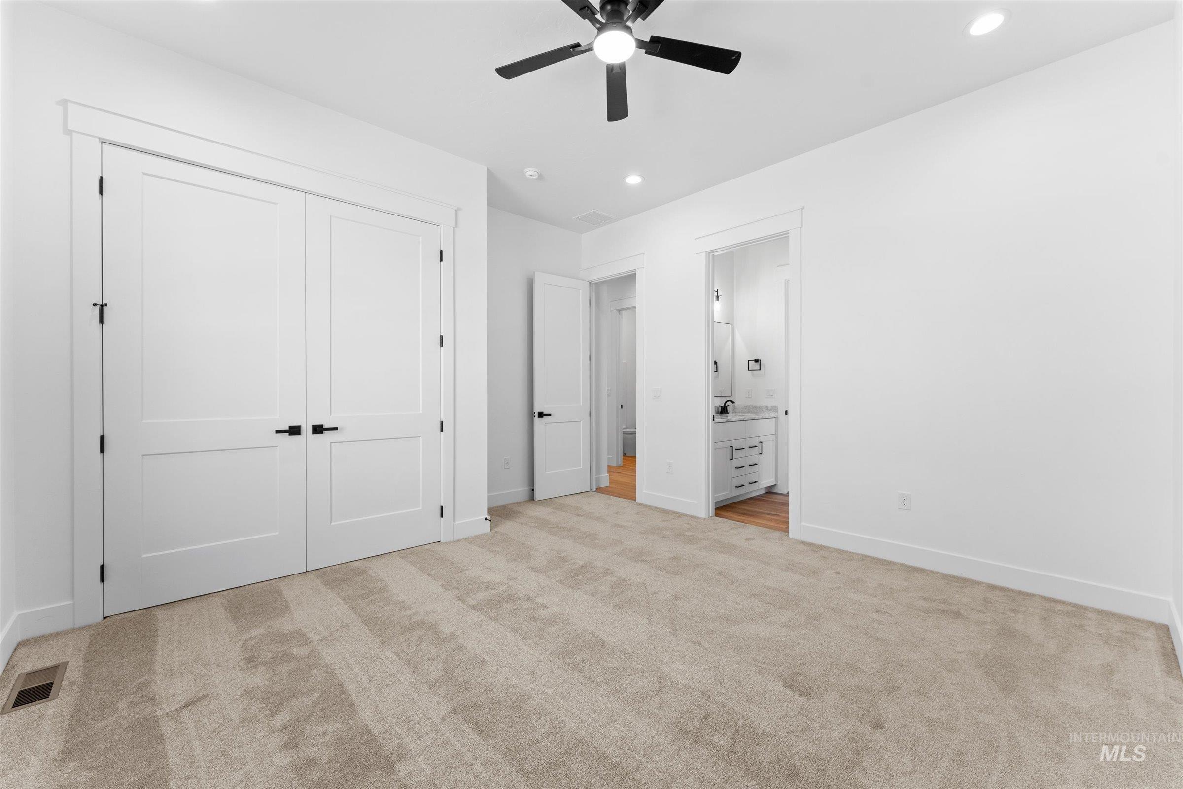 26219 Reed Lane Wilder, ID 83676 - Photo 15 of 35 Unfurnished bedroom with light colored carpet, ceiling fan, recessed lighting, connected bathroom, and a closet