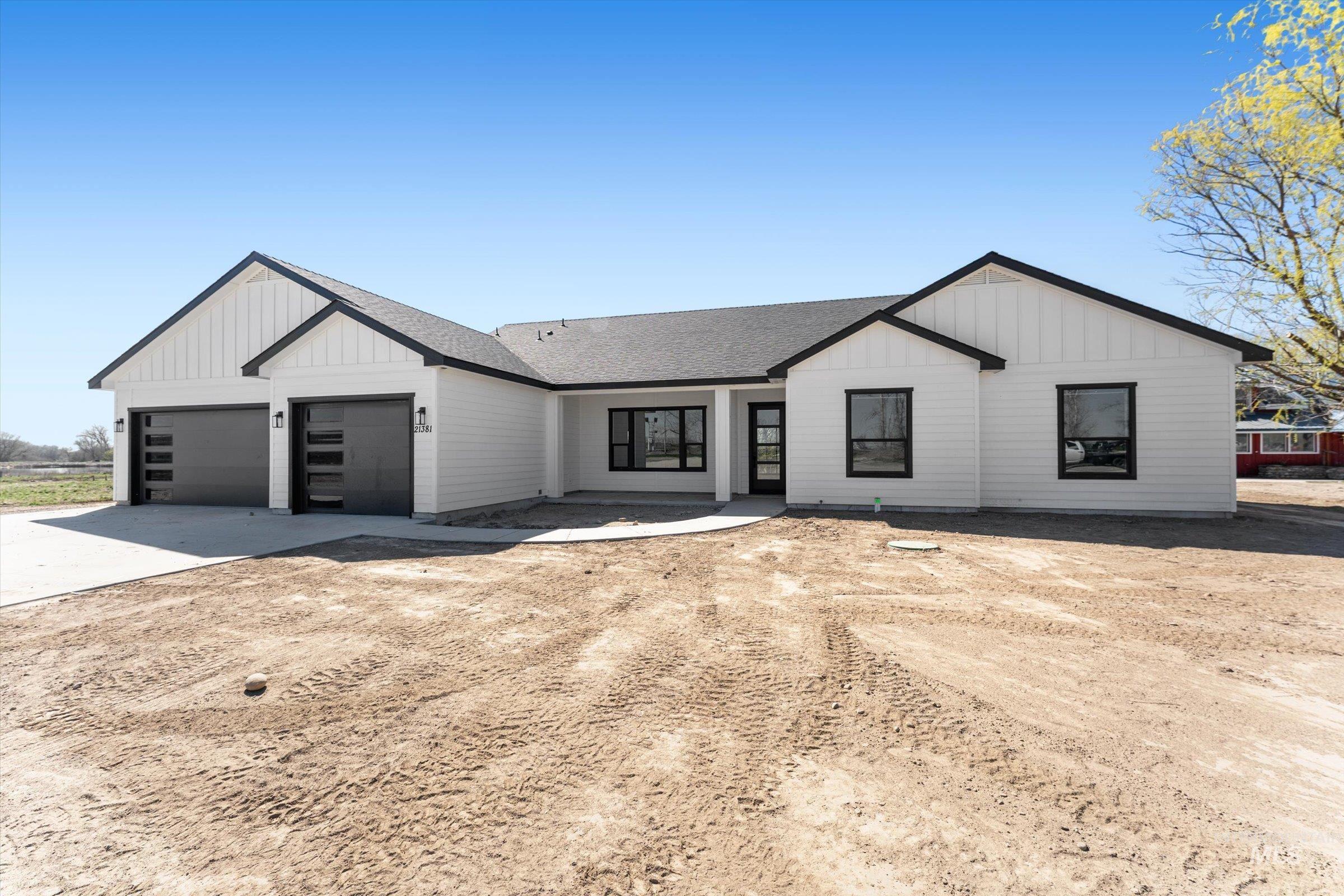 26219 Reed Lane Wilder, ID 83676 - Photo 2 of 35 Modern farmhouse style home with concrete driveway, roof with shingles, a garage, and board and batten siding